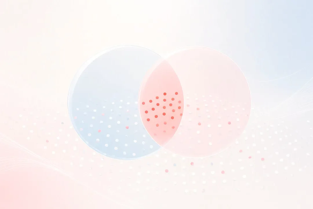 Light, airy abstract in pearl white, blush and pale sky blue: two translucent circles overlap above a field of soft dots, with a small cluster glowing coral where they meet. No people, logos or text.