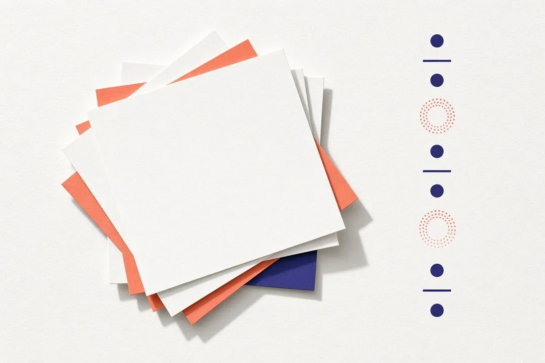 Bright paper-white abstract: a fanned stack of blank sheets in white, coral and indigo beside a neat column of indigo dots and lines, two of them faint dotted coral rings as if missing. No people, logos or text.